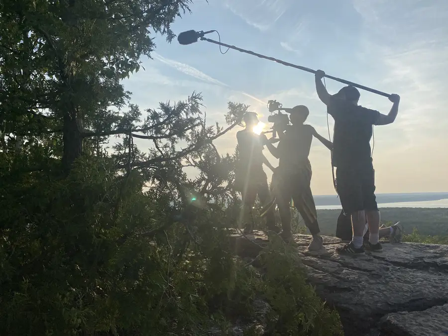 Film crew shooting at sunset on a rocky overlook