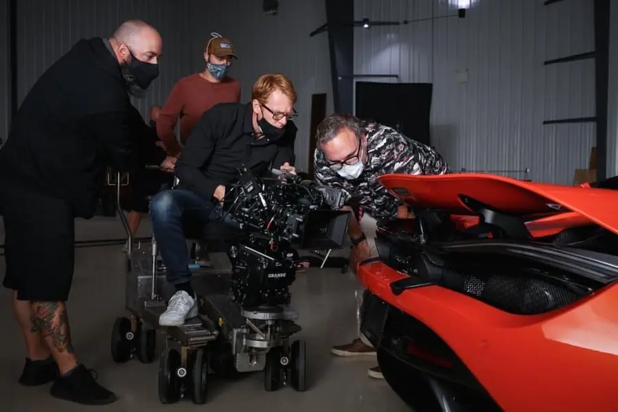 Camera crew filming a red car